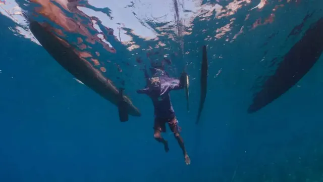 Diver beneath the tenders in Alor; diving Alor